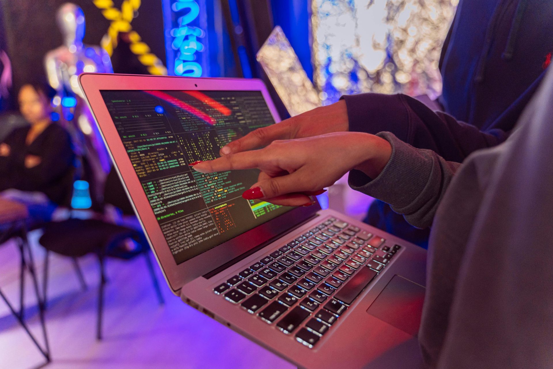 Eine lebhafte Szene mit Händen, die auf einen Computer mit angezeigtem Code zeigen, was auf einen Fokus auf Technologie hindeutet.