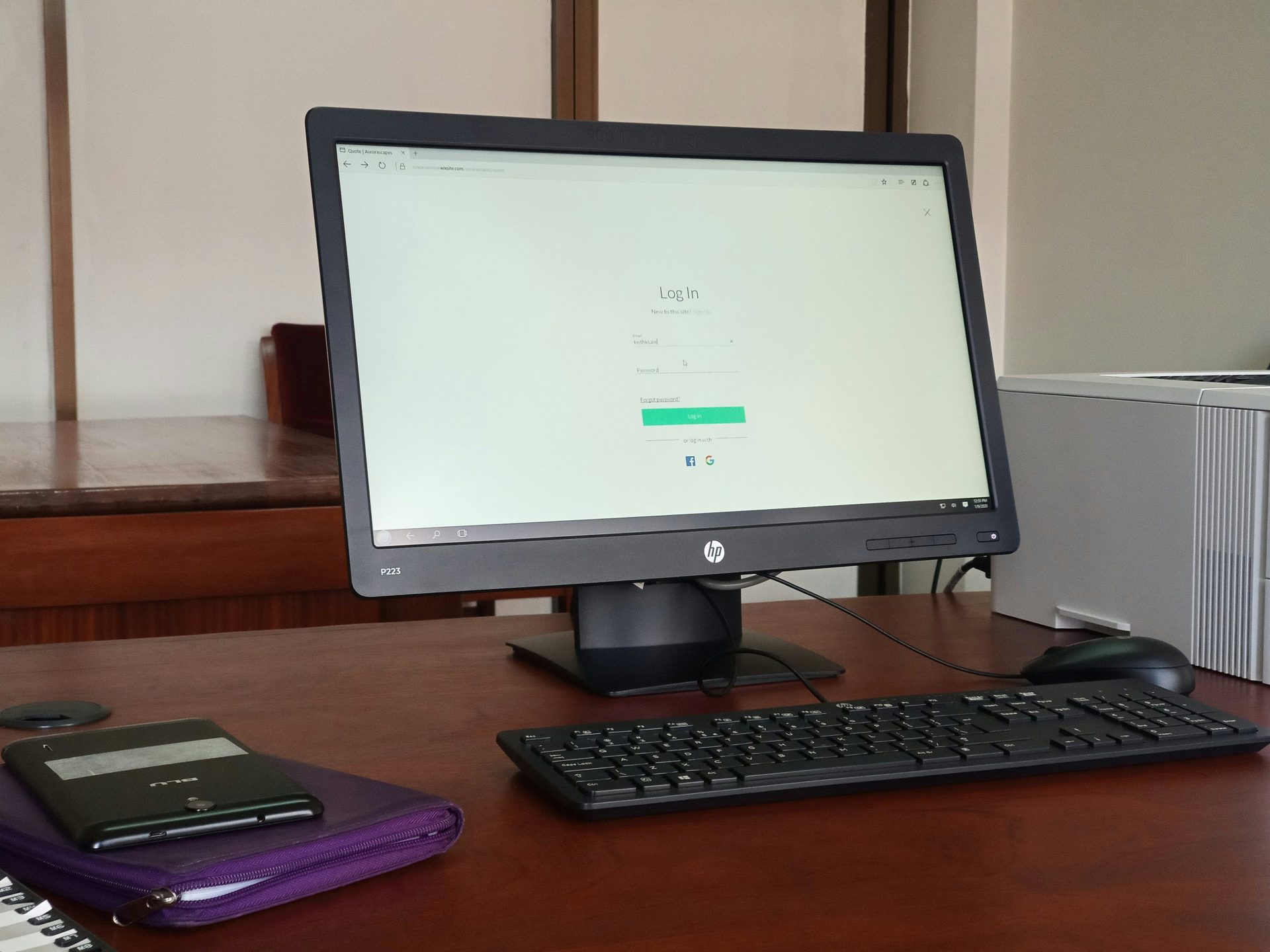 Ein schwarzer, eingeschalteter Computermonitor steht neben einer schwarzen Computertastatur.