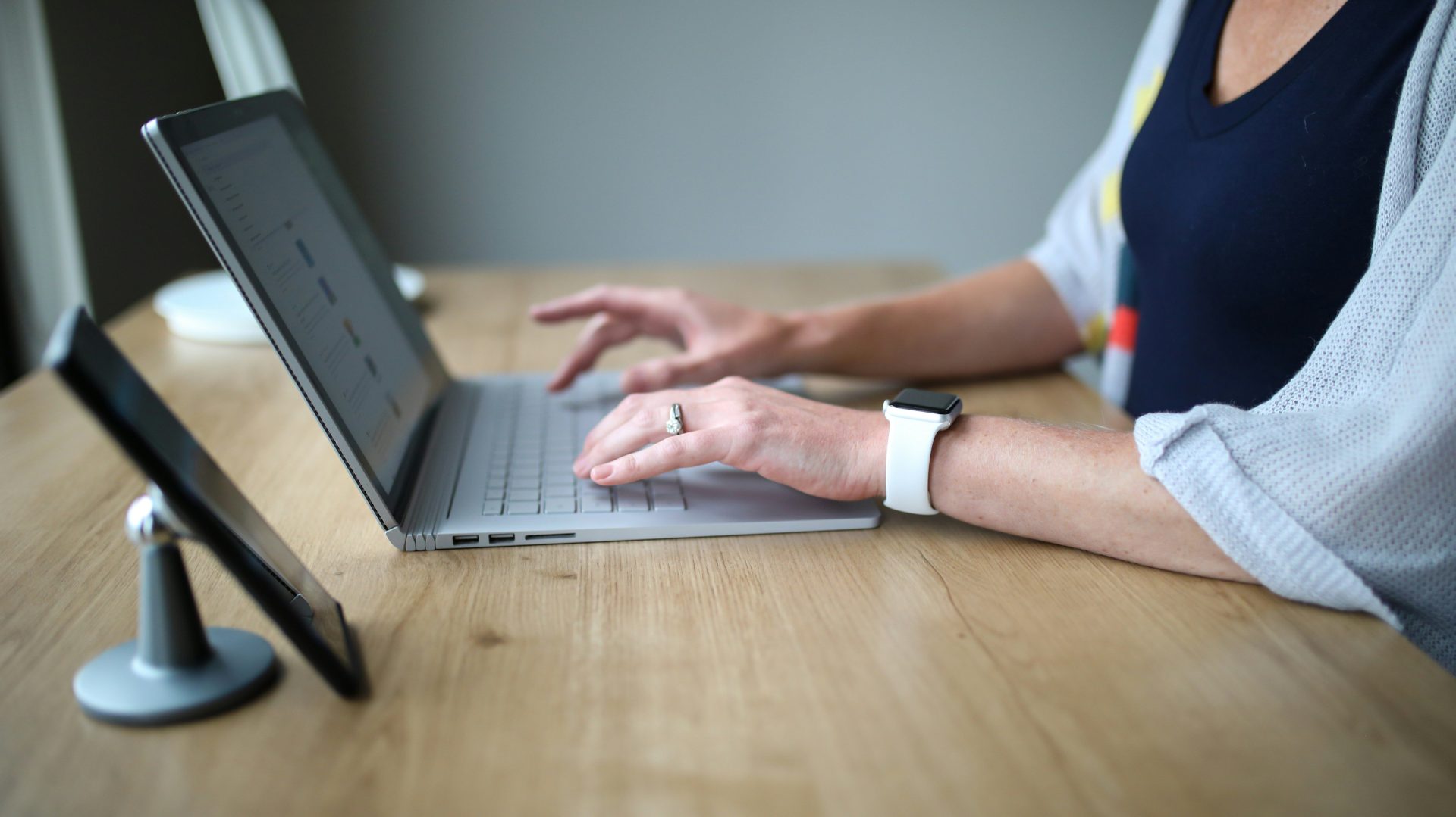 Person in weiß-blauem Hemd, die ein MacBook Pro benutzt
